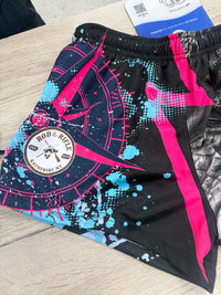 Close-up of actual Rod and Rifle pink footy shorts with light blue splashes and dots around the pink compass