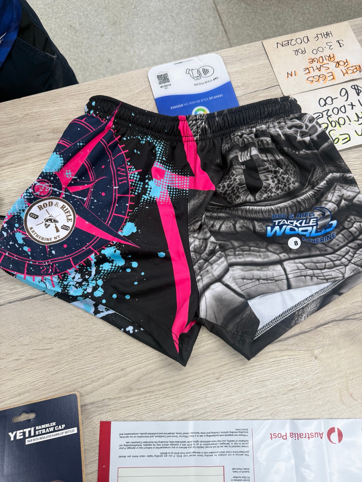 Actual Rod and Rifle pink footy shorts showing bright blue splashes around the pink compass and grey crocodile artwork
